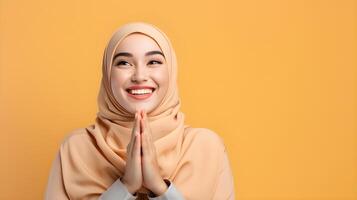 Süd-Ost asiatisch Frau tragen Schal ist beten und lächelnd auf Gelb Hintergrund foto