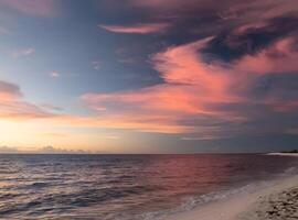 Sonnenuntergang Über das Ozean mit Wolken und Berge im das Hintergrund foto