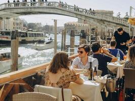 Venedig, Italien - - April 2. 2023. Menschen sind Sitzung beim das draußen Terrasse von ein klein Cafe im Venedig, Italien. foto