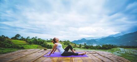 asiatische frau entspannen sich im urlaub. spielen, wenn Yoga. auf der balkonlandschaft naturfeld foto