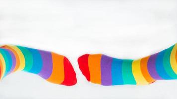 zwei linke Füße tragen Regenbogenflaggensocken. besuchbarkeit der lgbtq-Community foto