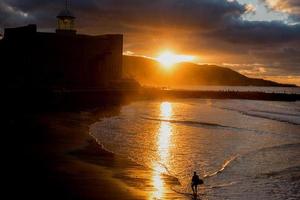 Surfen am Strand bei Sonnenuntergang foto