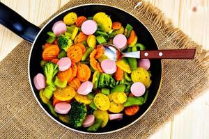 gedünstetes Gemüse Kartoffeln, Karotten und Brokkoli mit Würstchen foto