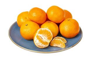 blaue Platte mit leuchtend orangefarbenen Mandarinen auf weißem Hintergrund. Studiofoto foto