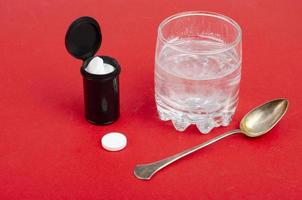 weiße runde Tabletten, die in einem Glas Wasser löslich sind. Studiofoto foto