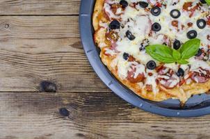hausgemachte Pizza mit Salami, Mozzarella und Oliven foto