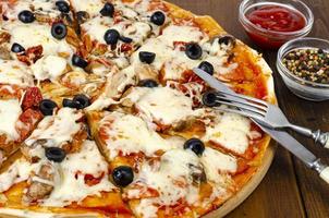 hausgemachte Pizza mit Peperoni, Champignons, Mozzarella und Oliven. Studiofoto foto