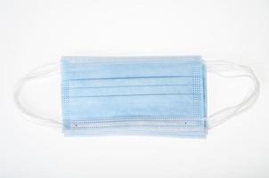 blaue medizinische Einwegmasken auf weißem Hintergrund, Schutz vor Coronavirus