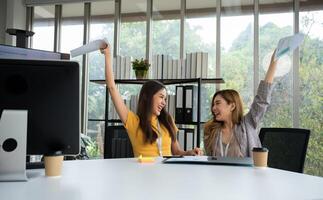 asiatisch Clever Büro oder Geschäftsfrau aufgeregt erfolgreich Geschäft Menschen, feiern gewinnen. zwei Geschäftsfrau suchen beim ein monatlich Zusammenfassung von Der Umsatz Das überschreiten Der Umsatz Ziele und leisten profitabel Wachstum foto