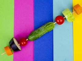 Bio-frisches Slises-Gemüse auf Holzstab. veganes oder gesundes Lebensmittelkonzept. minimalistisches Stillleben auf hellem Hintergrund der Farbe. foto