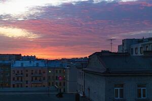 lebendig Frühling Sonnenuntergang Über Heilige petersburg, mit dramatisch Wolken und warm Farbtöne reflektieren aus das Stadt Gebäude foto