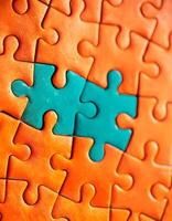 beschwingt blaugrün Puzzle Stück unter Orange Puzzles Hintergrund foto