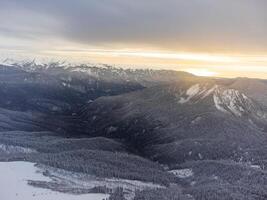 Aussicht von das Winter Sonnenuntergang und schneebedeckt Berge im Sotschi foto