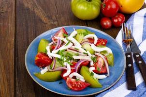 Gesunder Gemüsesalat mit Tomaten und Tintenfischstücken. Studiofoto. foto
