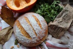 hausgemacht Sauerteig Brot frisch gebacken mit Gemüse und Grüns Dekoration foto