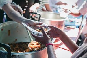 Portion das Arm im Gesellschaft durch spenden Essen . das Konzept von Hunger foto