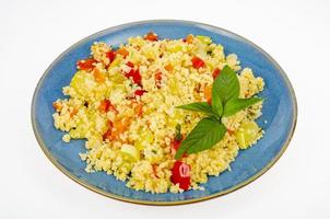 Vegetarischer Couscous-Pilaw mit Gemüse auf blauem Teller. Studiofoto foto