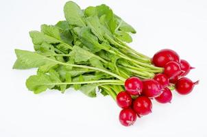 Haufen junger roter frischer Rettich mit grünen Blättern auf weißem Hintergrund, vegetarisches Diätmenü. Studiofoto foto