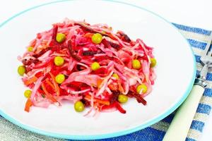 Salat von Rüben und Karotten mit Sauerkraut, Erbsen, Gewürzen foto