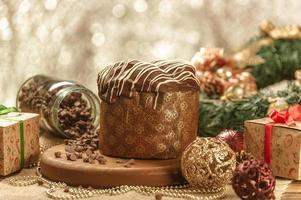 Schokoladenpanettone auf Holztisch mit Weihnachtsschmuck foto