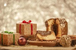 Scheibe Schokoladenpanettone auf Holzbrett mit Weihnachtsschmuck foto