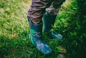 ein Person tragen Regen Stiefel Stehen im das Gras foto