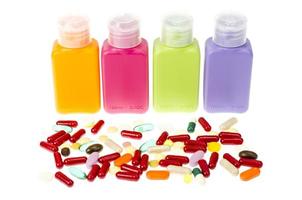 Mehrfarbige Plastikflaschen, Behälter mit Pillen und Kapseln auf weißem Hintergrund. foto
