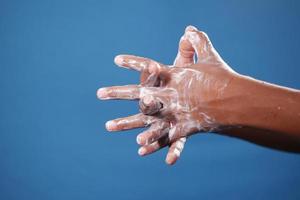 Kind kastenförmig Händewaschen mit Seife auf blauem Hintergrund foto