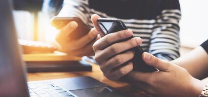 Geschäftsfrau und Geschäftsmann mit Smartphone zum vergleichen Sie und Teilen Über Fonds von finanziell während Arbeit von heim. foto