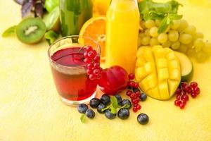 Glas mit gesundem Saft, Obst und Gemüse auf farbigem Hintergrund foto