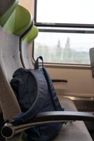 das Rucksack ist auf das Sitz, Reise Konzept. ein Blau Rucksack ist Lügen auf das Sitz von ein Passagier Zug. Reise zu Deutschland. foto