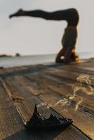 Mädchen üben Yoga und meditieren auf das Strand beim Sonnenuntergang. foto