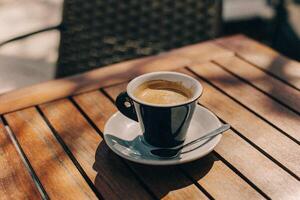 Tasse von schwarz Kaffee auf ein Tabelle im ein Straße Cafe. foto