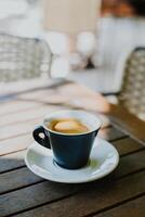 Tasse von schwarz Kaffee auf ein Tabelle im ein Straße Cafe. foto