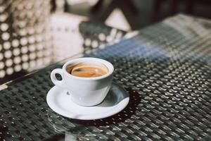 Tasse von schwarz Kaffee auf ein Tabelle im ein Straße Cafe. foto