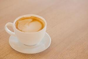 Tasse von Kaffee auf ein hölzern Tisch. Weiß Keramik Tasse. foto