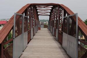 Jahrgang rot Metall Brücke auf wolkig Tag foto