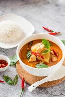 traditionell thailändisch Hähnchen rot Curry mit frisch Gemüse und Kraut im Schüssel auf Tisch, thailändisch Essen Konzept mit Reis foto