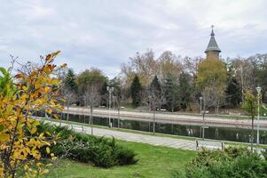 Herbst auf das Ufer von Fluss bega.wunderschön Park im begann Kanal und orthodox Kathedrale im das Hintergrund. Park Bäume reflektieren im das Wasser während ein sonnig Tag foto