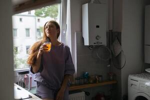 kontemplativ Frau mit Tee durch Fenster foto