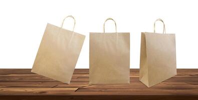Papier Taschen, Einkaufen Taschen auf ein hölzern Tabelle Weiß Hintergrund foto