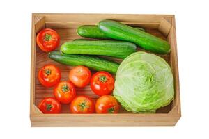 Gurken, Tomaten und Kohl im ein hölzern Box isolieren. foto