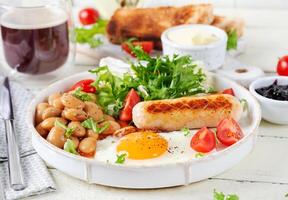Englisch Frühstück. Keto Frühstück. gebraten Ei, Bohnen, Hähnchen Würstchen und Kaffee Tasse. foto