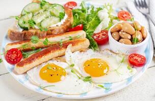 Englisch Frühstück. Keto Frühstück. gebraten Ei, Bohnen, Hähnchen Würstchen und Kaffee Tasse. foto