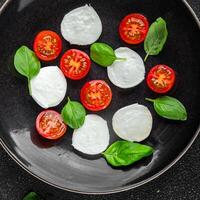 Caprese Salat Mozzarella, Tomate, Basilikum frisch Essen lecker gesund Essen Kochen Vorspeise Mahlzeit Essen Snack auf das Tabelle Kopieren Raum Essen Hintergrund rustikal oben Aussicht foto