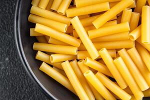 Tortiglioni roh Pasta Kochen Vorspeise Mahlzeit Essen Snack auf das Tabelle Kopieren Raum Essen Hintergrund rustikal foto