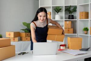 Frau asiatisch im ein online Geschäft prüfen das Kunde Adresse und Paket Information auf das Laptop. online Einkaufen Konzept foto