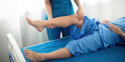 physisch Therapeut asiatisch Frau, tun Bein Physiotherapie zum Alten Mann zu behandeln Arthrose und Nerv Schmerzen im das Bein zu Pflege- beim Zuhause und Gesundheit Pflege Konzept foto