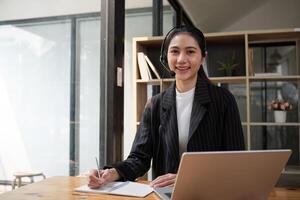 Anruf Center freundlich Frau asiatisch im Büro zum Kunde Service, technisch Unterstützung und Beratung, Kontakt und Kommunikation mit Mitarbeiter Operator im Hilfe Schreibtisch Agentur foto