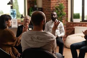 Person, die Erfolge mit einer Gruppe von Personen bei einem Meeting teilt foto